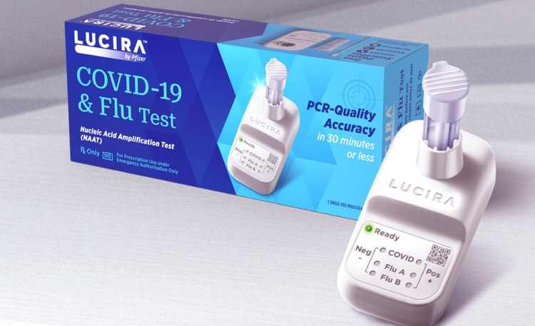 An image of the The LUCIRA® by Pfizer COVID-19 & Flu Test sitting on the right and the packaging sitting on the left.
